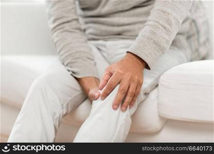 people, health care and problem concept - close up of senior man suffering from knee ache. close up of senior man suffering from knee ache
