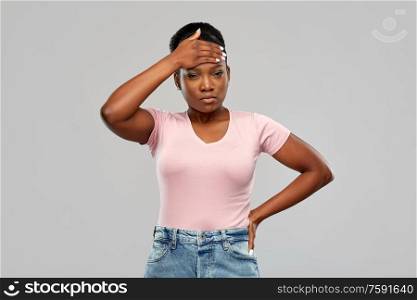 people, health problem and stress concept - unhappy african american woman suffering from headache or fever over grey background. african american woman having headache or fever