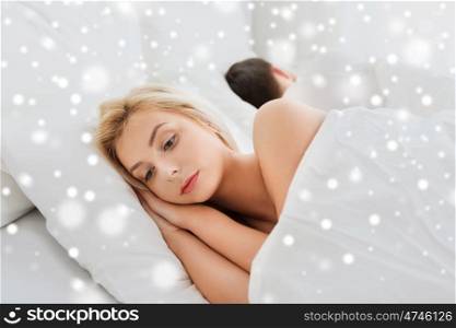 people, health, sleep disorder concept - couple lying in bed at home and young woman suffering from insomnia over snow