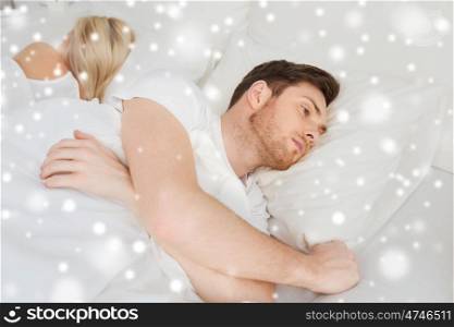 people, health, sleep disorder concept - couple lying in bed at home and young man suffering from insomnia over snow