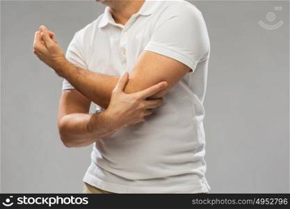 people, healthcare and problem concept - close up of man suffering from pain in hand over gray background. close up of man suffering from pain in hand