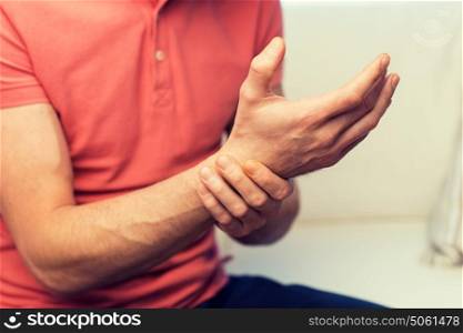people, healthcare and problem concept - close up of man suffering from pain in hand oe wrist at home. close up of man with pain in hand at home