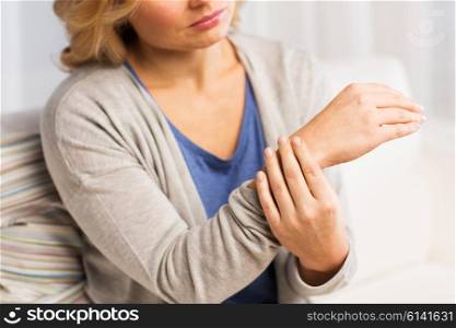 people, healthcare and problem concept - close up of woman suffering from pain in hand at home