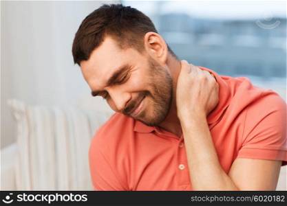 people, healthcare and problem concept - unhappy man suffering from neck pain at home