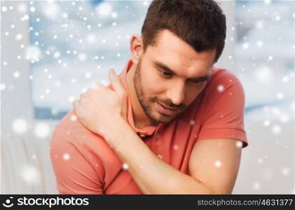 people, healthcare and problem concept - unhappy man suffering from neck pain at home over snow