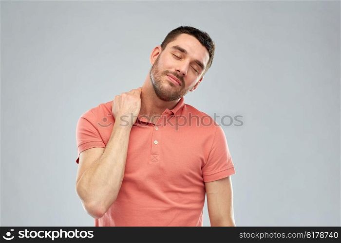 people, healthcare and problem concept - unhappy man suffering from neck pain over gray background