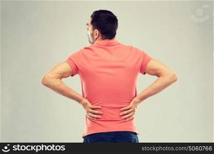 people, healthcare and problem concept - unhappy man suffering from pain in back or reins. unhappy man suffering from backache at home