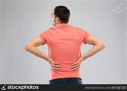 people, healthcare and problem concept - unhappy man suffering from pain in back or reins