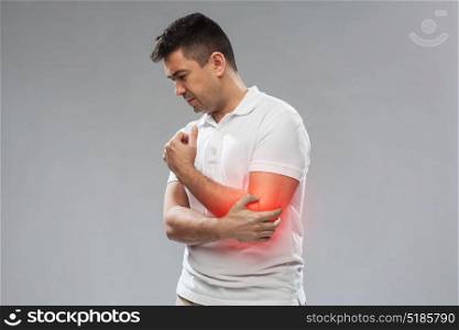 people, healthcare and problem concept - unhappy man suffering from pain in hand over gray background. unhappy man suffering from pain in hand