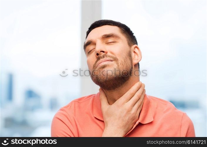 people, healthcare and problem concept - unhappy man touching her neck and suffering from throat pain at home