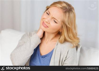people, healthcare and problem concept - unhappy woman suffering from neck pain at home