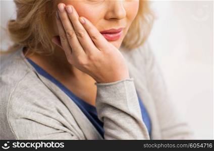 people, healthcare, dentistry and problem concept - close up of unhappy woman suffering toothache at home