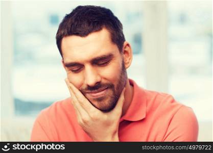 people, healthcare, dentistry and problem concept - unhappy man suffering toothache at home. unhappy man suffering toothache at home