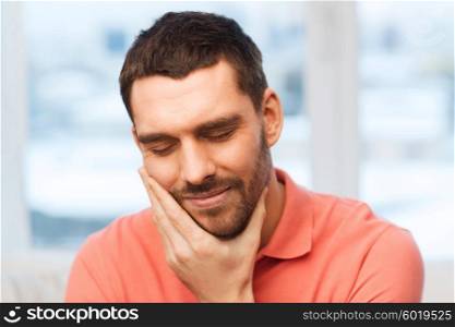 people, healthcare, dentistry and problem concept - unhappy man suffering toothache at home