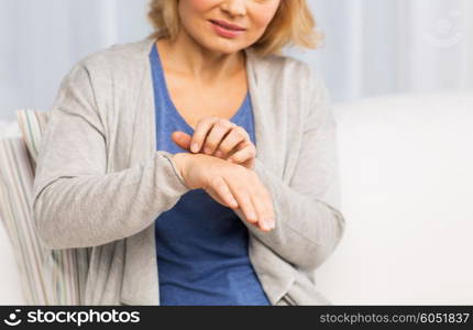 people, healthcare, dermatology, allergy and health problem concept - close up of unhappy woman suffering from hand inch at home