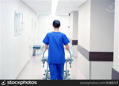 people, healthcare, reanimation and medicine concept - nurse carrying hospital gurney to emergency room. nurse carrying hospital gurney to emergency room