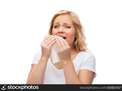 people, healthcare, rhinitis, cold and allergy concept - unhappy woman with paper napkin sneezing