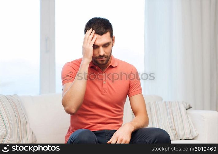 people, healthcare, stress and problem concept - unhappy man suffering from headache at home