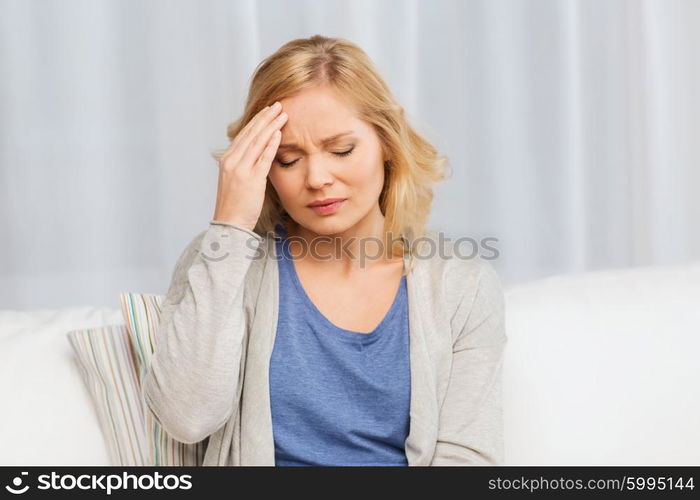 people, healthcare, stress and problem concept - unhappy woman suffering from headache at home