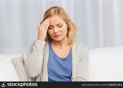 people, healthcare, stress and problem concept - unhappy woman suffering from headache at home