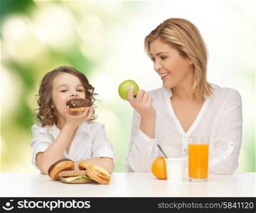 people, healthy lifestyle, family and food concept - happy mother and daughter eating healthy breakfast over green background