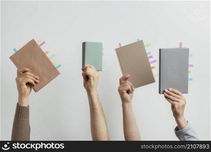people holding books with colorful reminders stickers