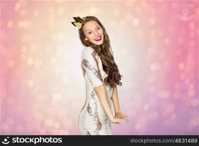 people, holidays and celebration concept - happy young woman or teen girl in party dress and golden princess crown over rose quartz and serenity lights background