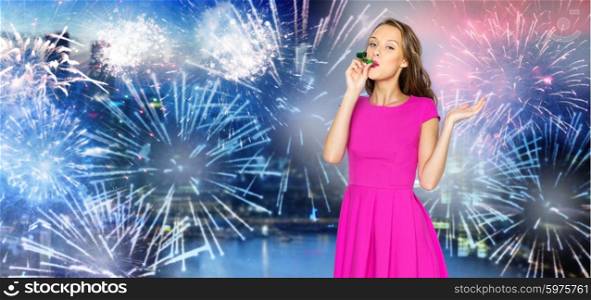 people, holidays and celebration concept - happy young woman or teen girl in pink dress and party cap over firework at night city background
