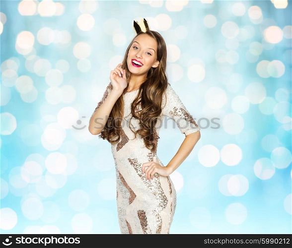 people, holidays and celebration concept - happy young woman or teen girl in party dress and princess crown over blue lights background
