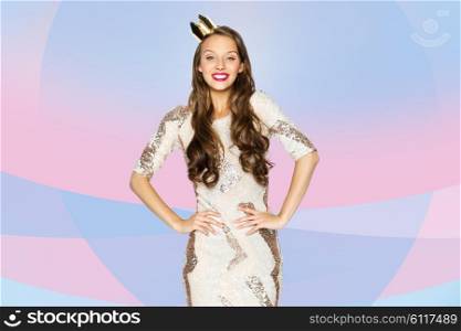 people, holidays and celebration concept - happy young woman or teen girl in party dress and princess crown over pink violet background
