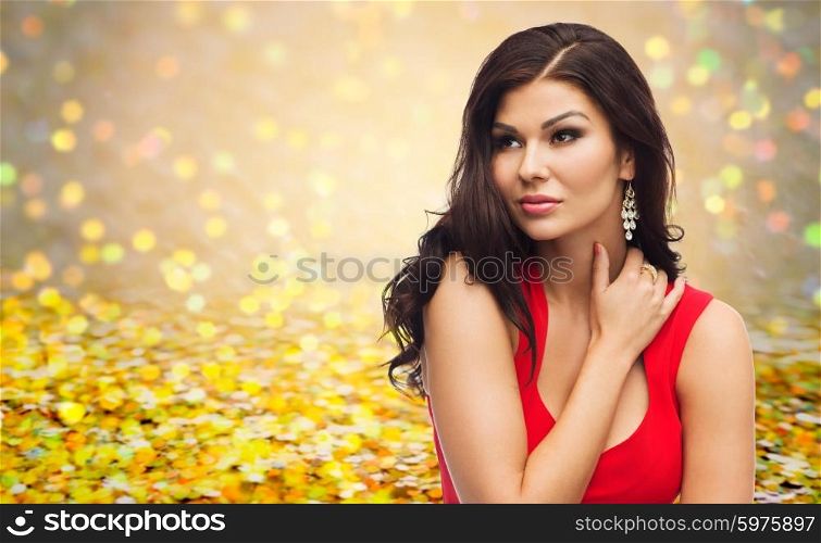 people, holidays and fashion concept - beautiful sexy woman in red dress over golden glitter or holidays lights background
