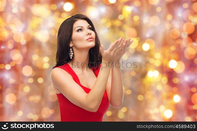 people, holidays and fashion concept - beautiful sexy woman in red dress over lights background