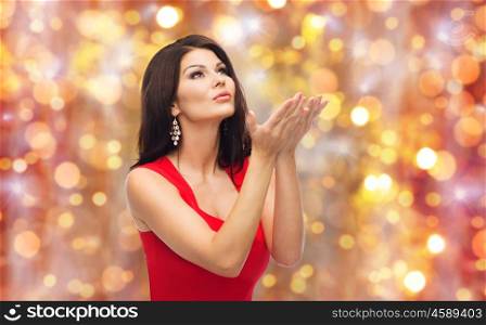 people, holidays and fashion concept - beautiful sexy woman in red dress over lights background