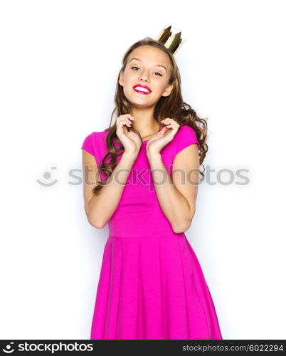 people, holidays and fashion concept - happy young woman or teen girl in pink dress and princess crown