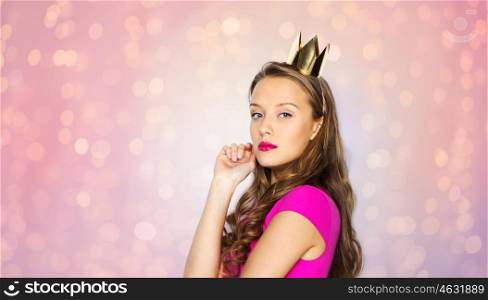 people, holidays and fashion concept - young woman or teen girl in pink dress and princess crown over rose quartz and serenity lights background