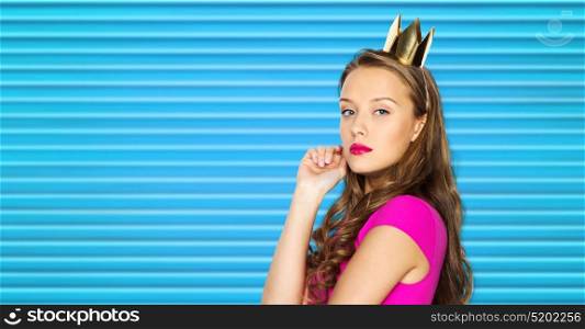 people, holidays and fashion concept - young woman or teen girl in pink dress and princess crown over blue ribbed background. young woman or teen girl in pink dress