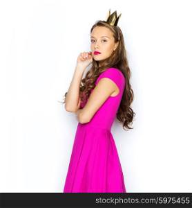people, holidays and fashion concept - young woman or teen girl in pink dress and princess crown