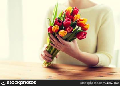 people, holidays and gardening concept - close up of woman holding tulip flowers