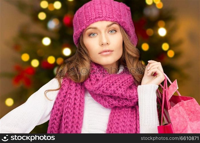 people, holidays and sale concept - woman with shopping bags over christmas tree lights background. woman with shopping bags over christmas lights