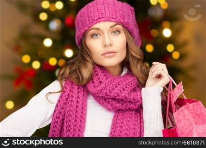 people, holidays and sale concept - woman with shopping bags over christmas tree lights background. woman with shopping bags over christmas lights