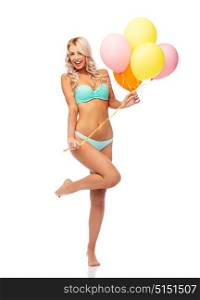 people, holidays and summer party concept - happy smiling young woman in bikini swimsuit with air balloons over white background. happy woman in bikini swimsuit with air balloons