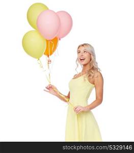 people, holidays and summer party concept - happy young woman or teen girl in pink dress with helium air balloons. happy woman in dress with helium air balloons