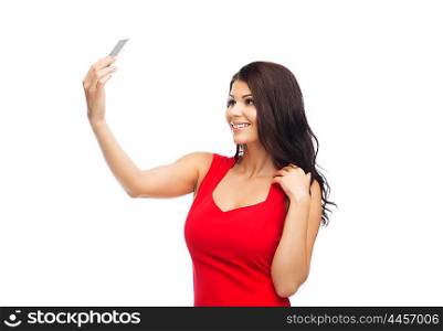 people, holidays and technology concept - beautiful sexy woman in red dress taking selfie picture by smartphone