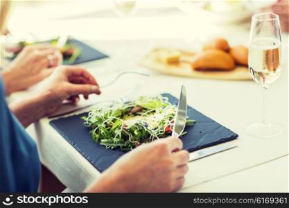 people, holidays, celebration and lifestyle concept - close up of woman eating salad appetizer for dinner at restaurant