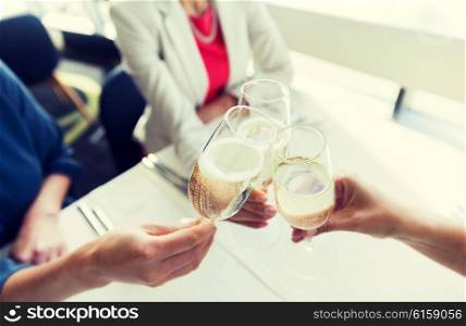 people, holidays, celebration and lifestyle concept - close up of women clinking champagne glasses at restaurant