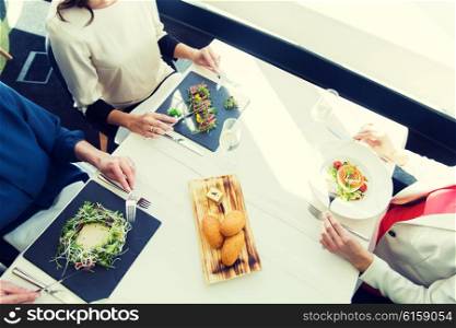 people, holidays, celebration and lifestyle concept - close up of women eating appetizer for dinner at restaurant