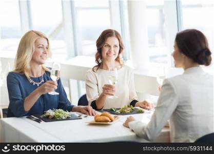 people, holidays, celebration and lifestyle concept - happy women drinking champagne at restaurant