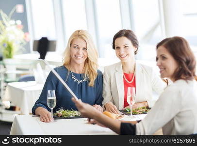 people, holidays, celebration and lifestyle concept - happy women with smartphone selfie stick taking picture at restaurant