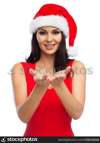 people, holidays, christmas and advertisement concept - beautiful sexy woman in santa hat and red dress showing something on empty hands