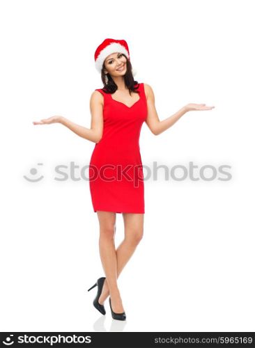people, holidays, christmas and advertisement concept - beautiful sexy woman in santa hat and red dress showing something on empty hands